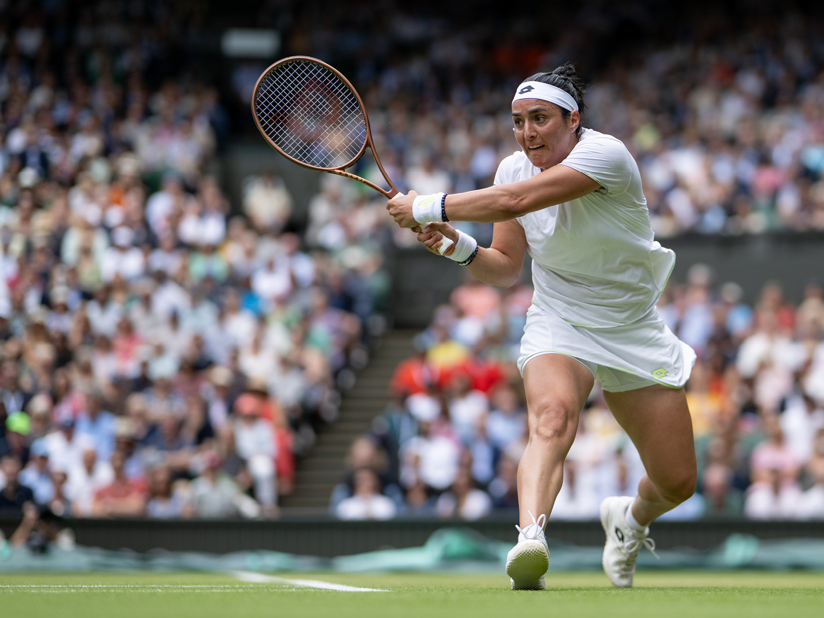 Women's tennis player Ons Jabeur hitting the ball during a match on Centre Court at Wimbledon in 2023