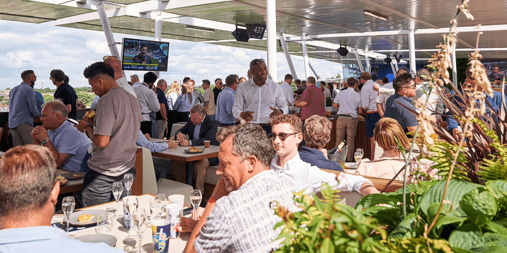 Guests sat down in the sun on the terrace enjoying the experience in the Skyline hospitality facility aT Edgbaston Stadium for a cricket match 