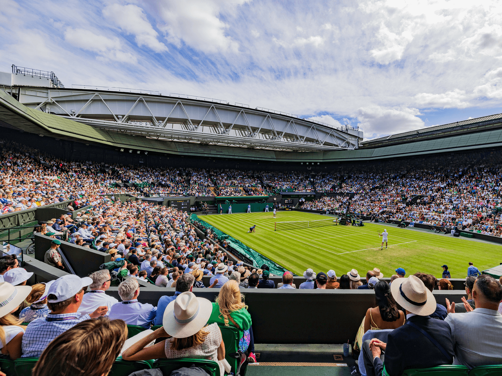View of Centre Court with the crowd and players on court at The Championships Wimbledon