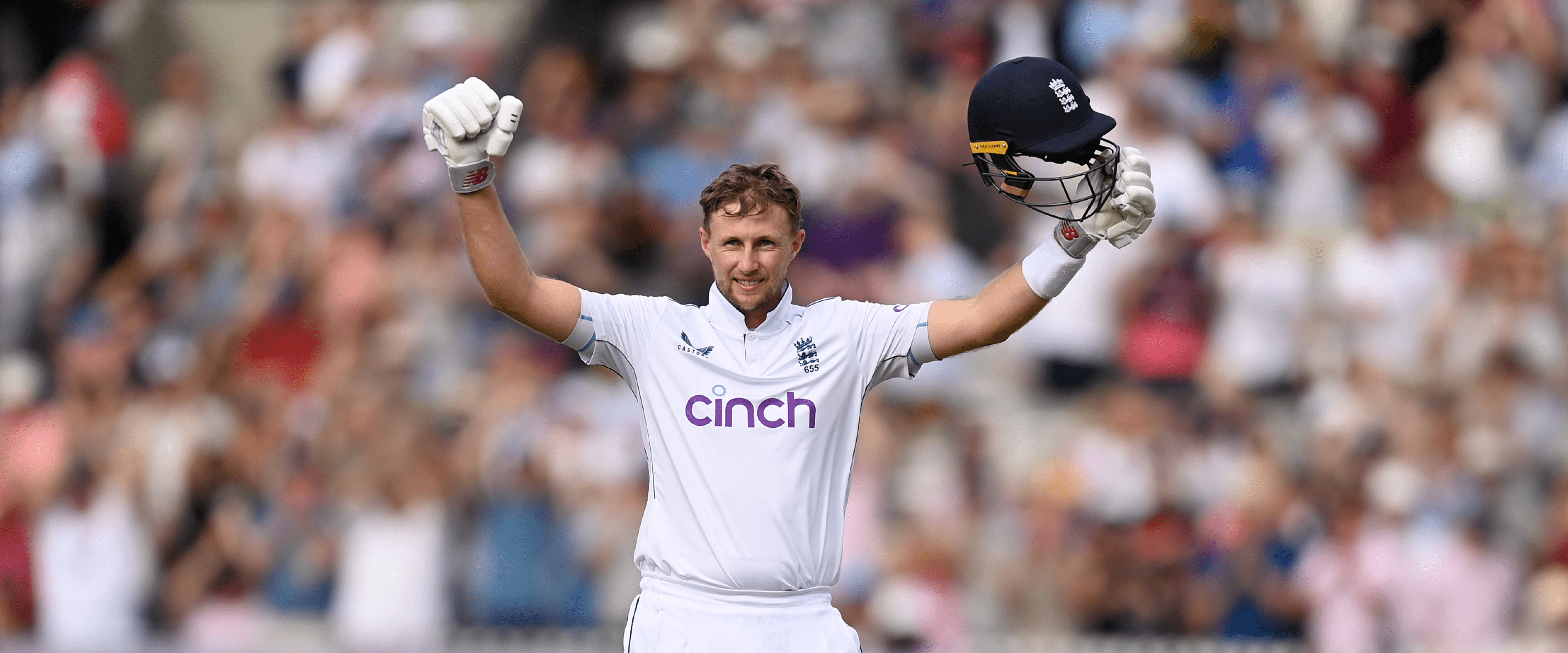 England cricket player Joe Root waving to the crowd whilst coming off the pitch in a Test Match
