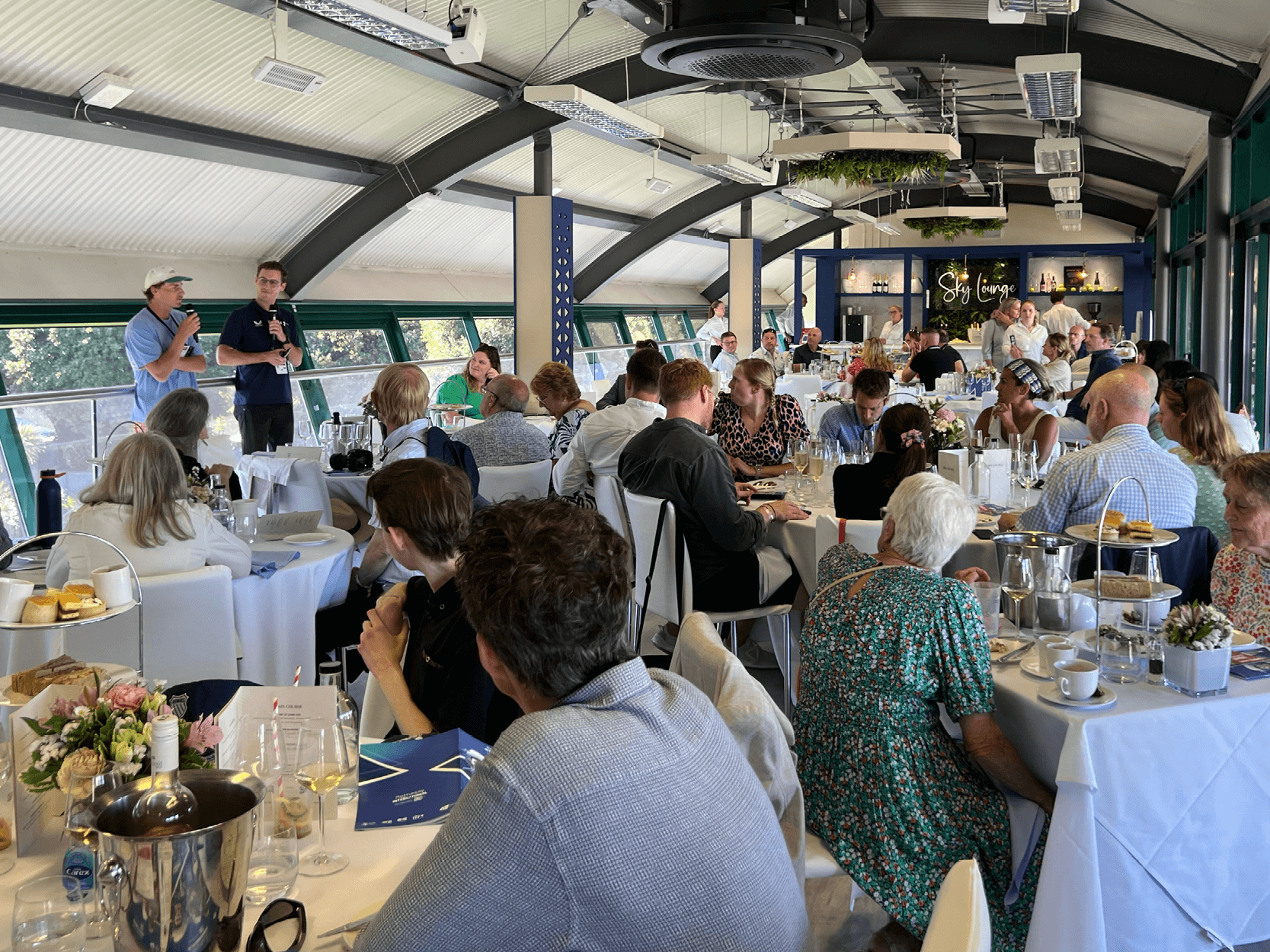 View of guests sat in The Sky Lounge hospitality facility listening to guest speaker and Australian tennis player Max Purcell