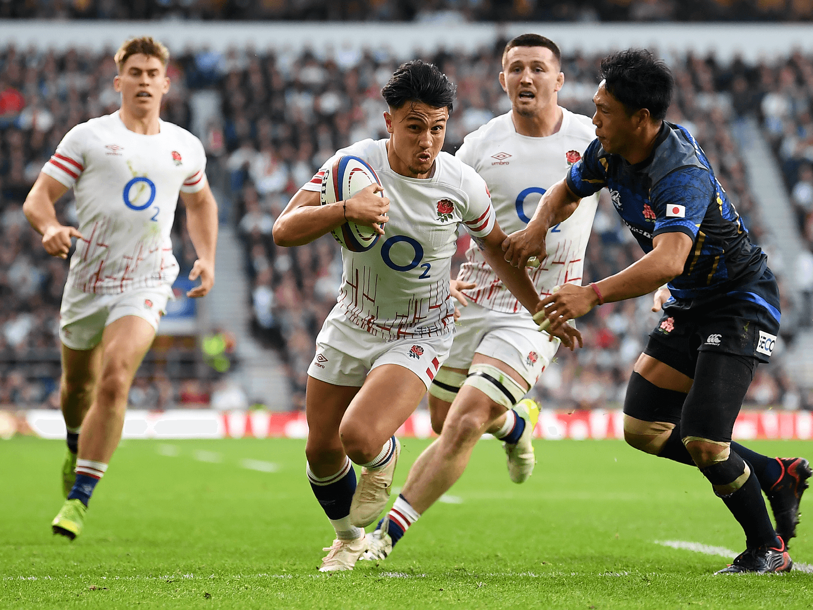 England rugby player Marcus Smith running with the ball against Japan during a rugby match