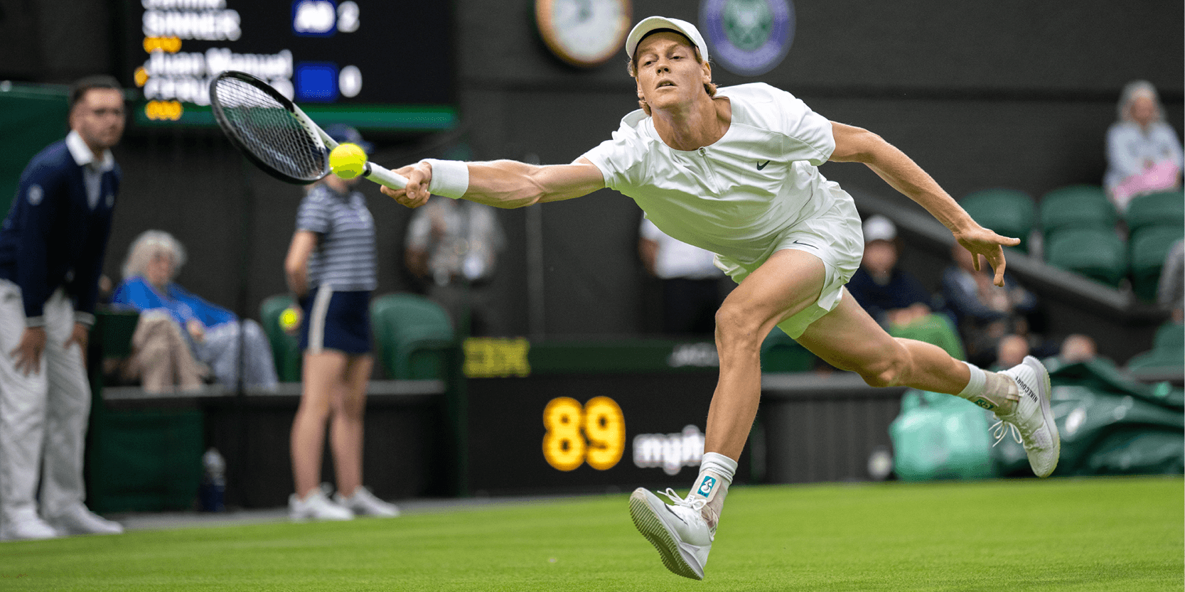 Men's tennis player Jannik Sinner hitting a forehand shot on Centre Court at Wimbledon