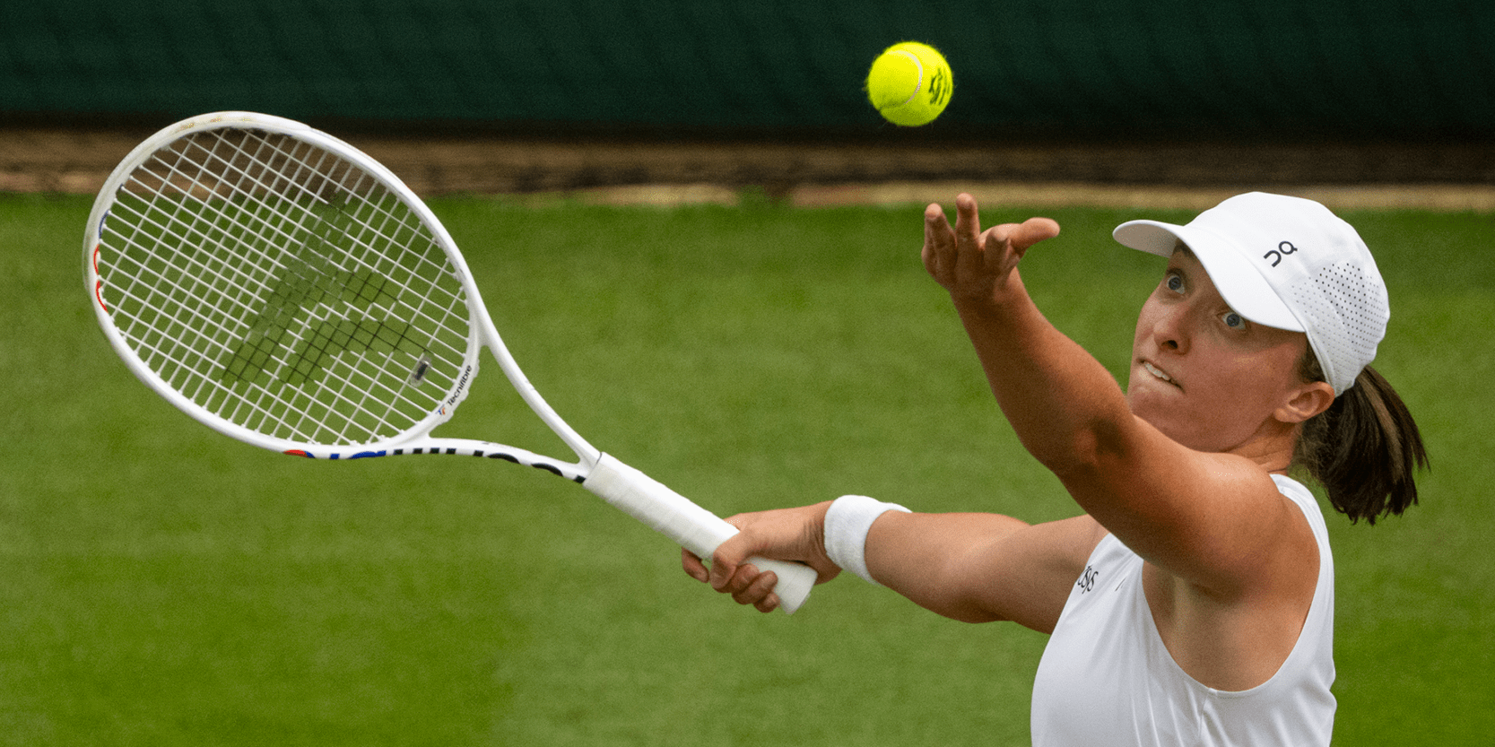 Tennis player Iga Swiatek serving during a match at Wimbledon in 2024
