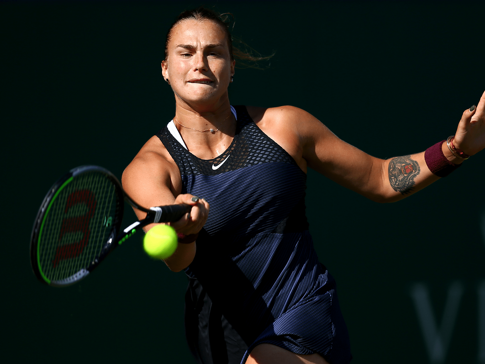 Women's tennis player Aryna Sabalenka hitting the ball during a shot in a match