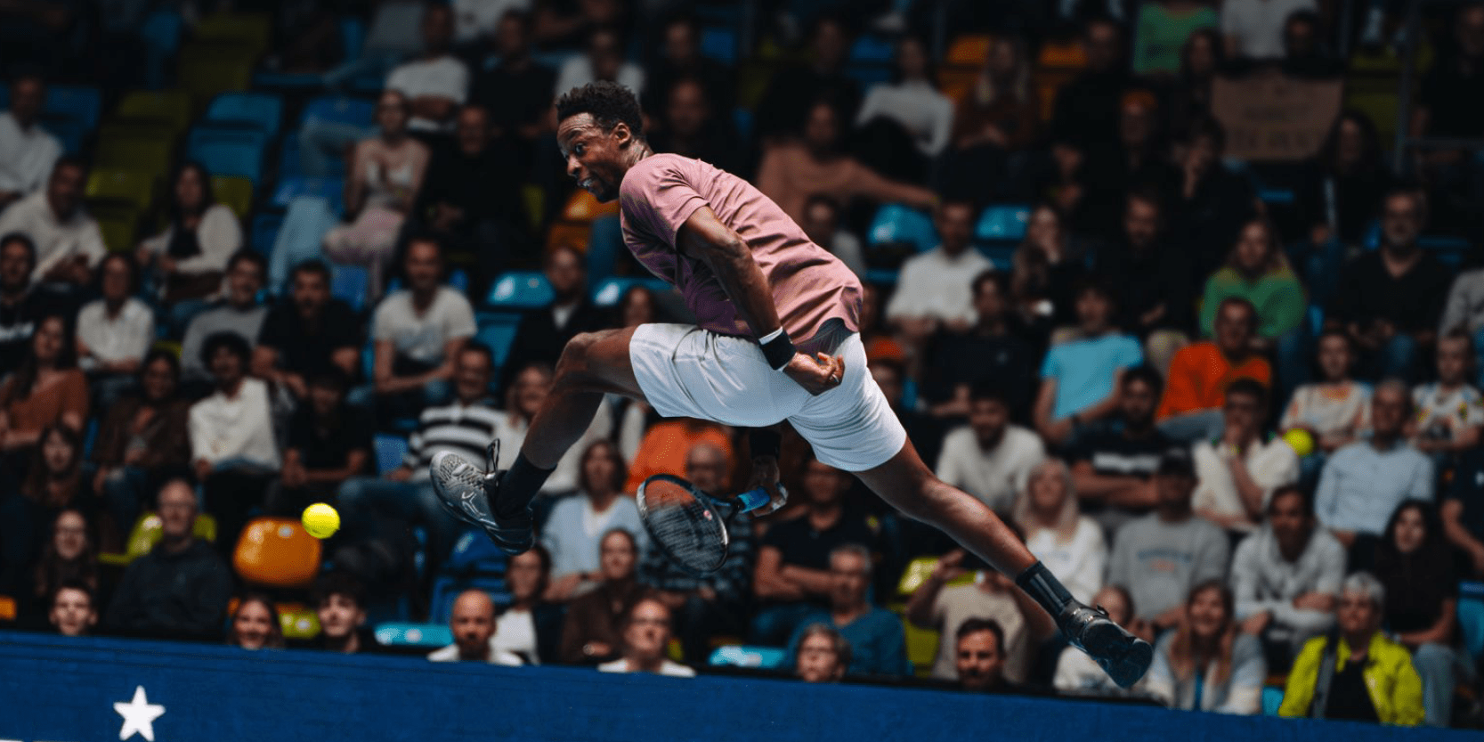 Tennis player Gael Monfils hitting the tennis ball doing a tweener during a match for the UTS tennis tournament 