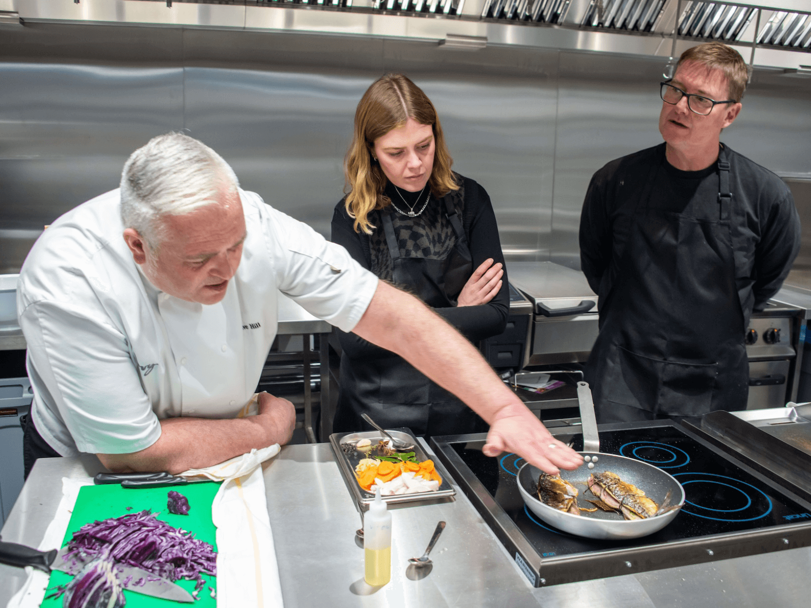 Chef leading a cooking course and teaching attendees how to make a dish at an Xcelerate class