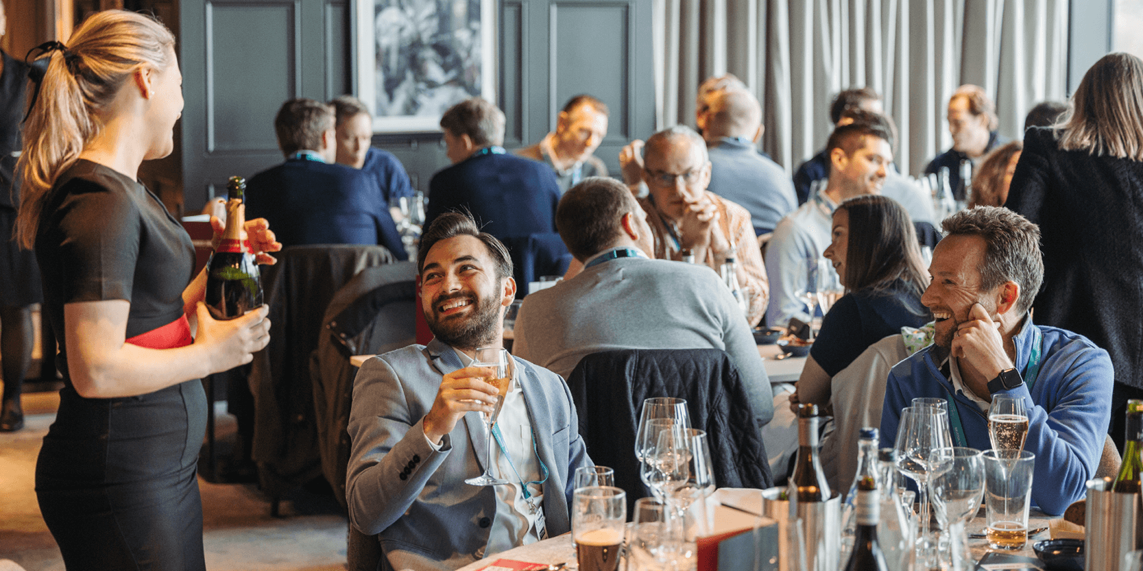 Hostess in The East Wing at Allianz Stadium talking to guests in hospitality whilst pouring Champagne at the rugby