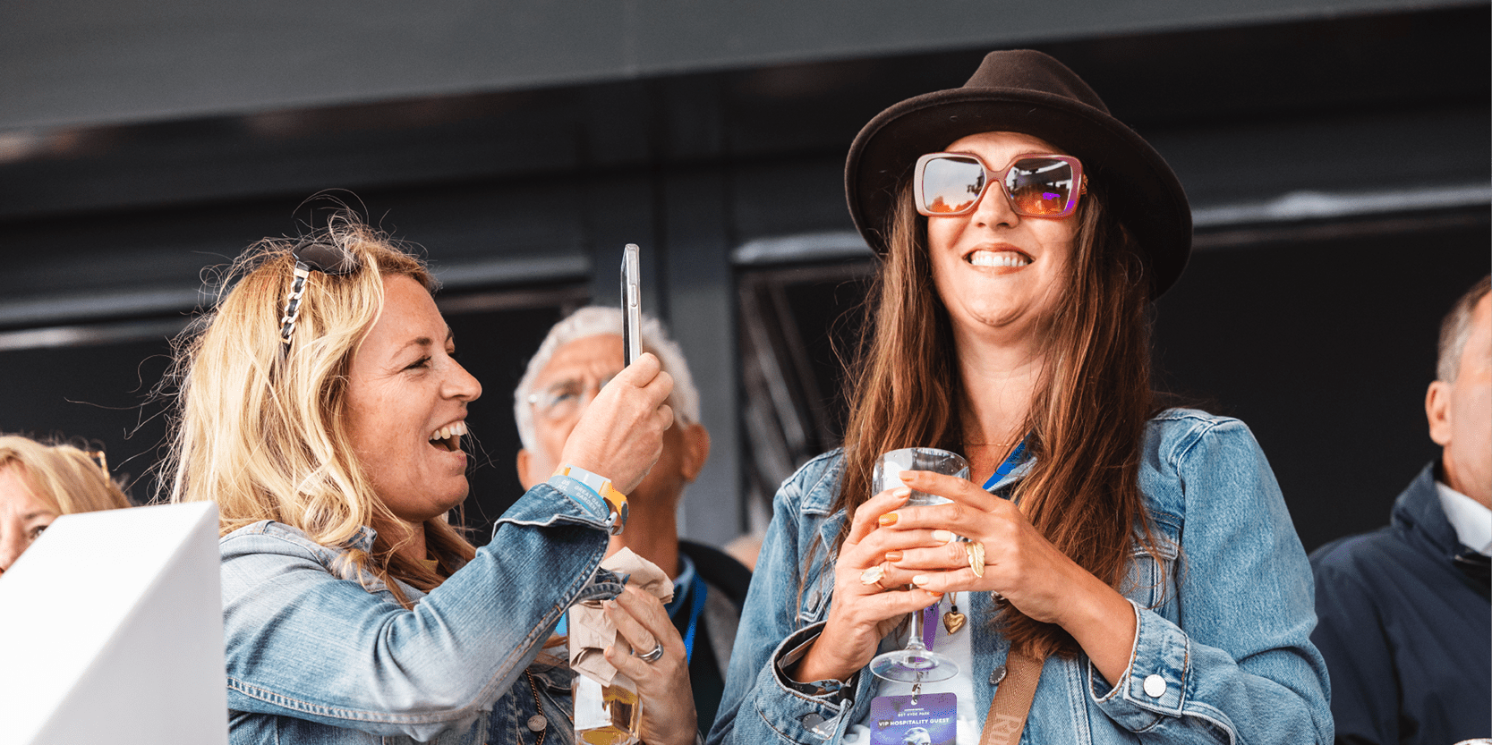 Guests on the Great Oak Roof Garden Terrace at BST Hyde Park in hospitality taking photos of each other and smiling at a concert