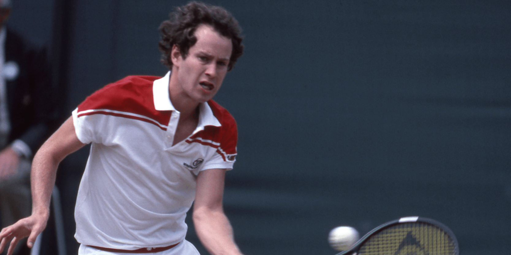 American former tennis player John McEnroe hitting the ball during a match at Wimbledon