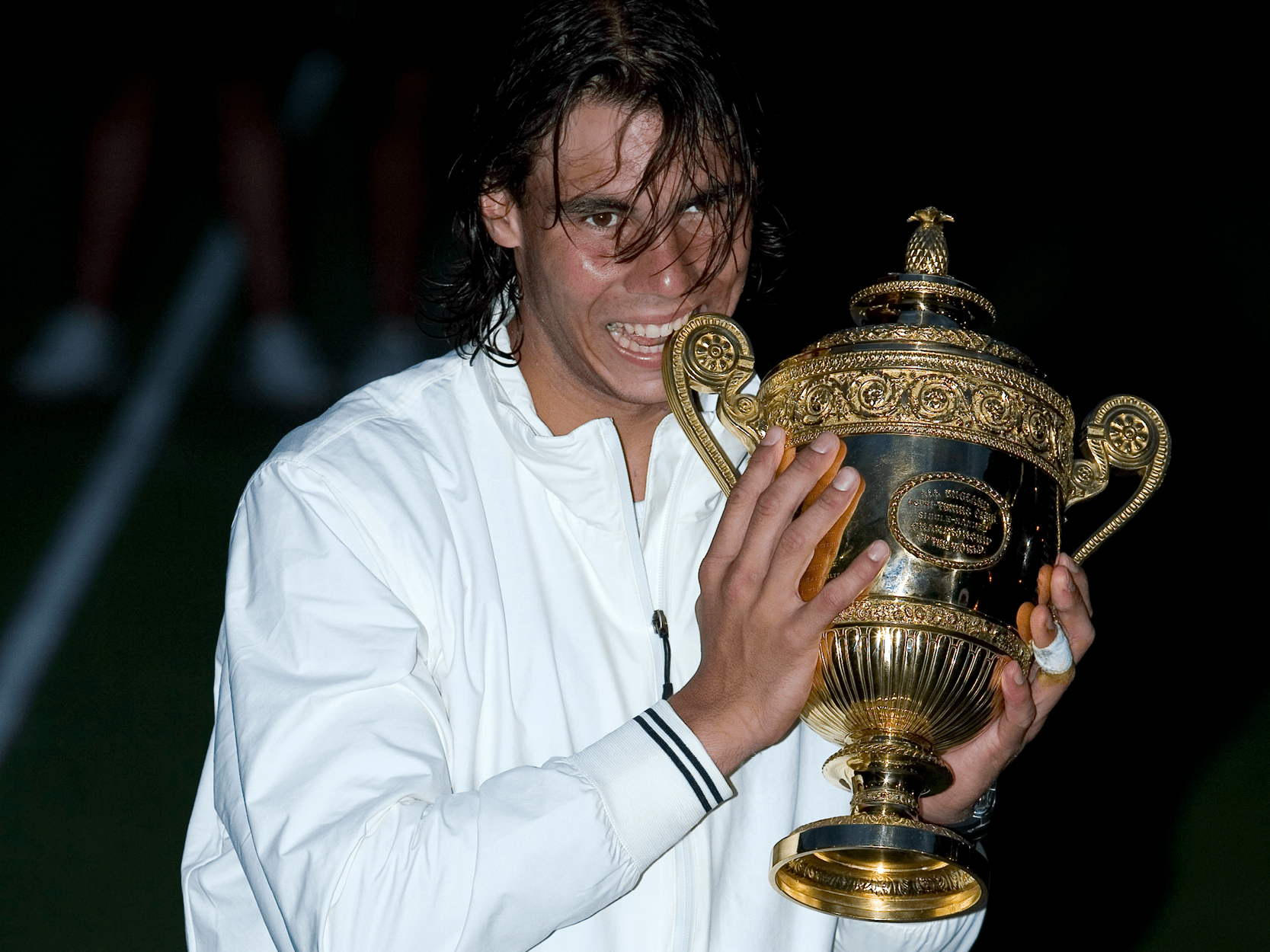 Tennis player and former World Number One Rafael Nadal holding the trophy after winning the final at The Championships Wimbledon