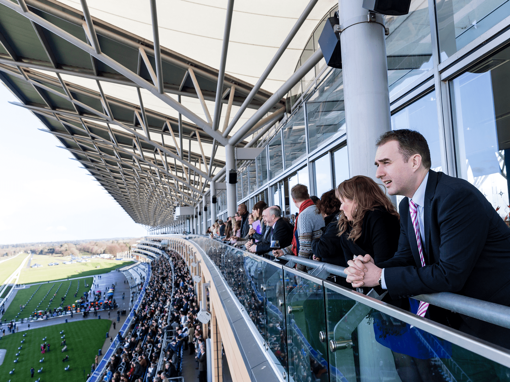 Guests on a balcony in hospitality watching the winning straight at Ascot Racecourse for Royal Ascot