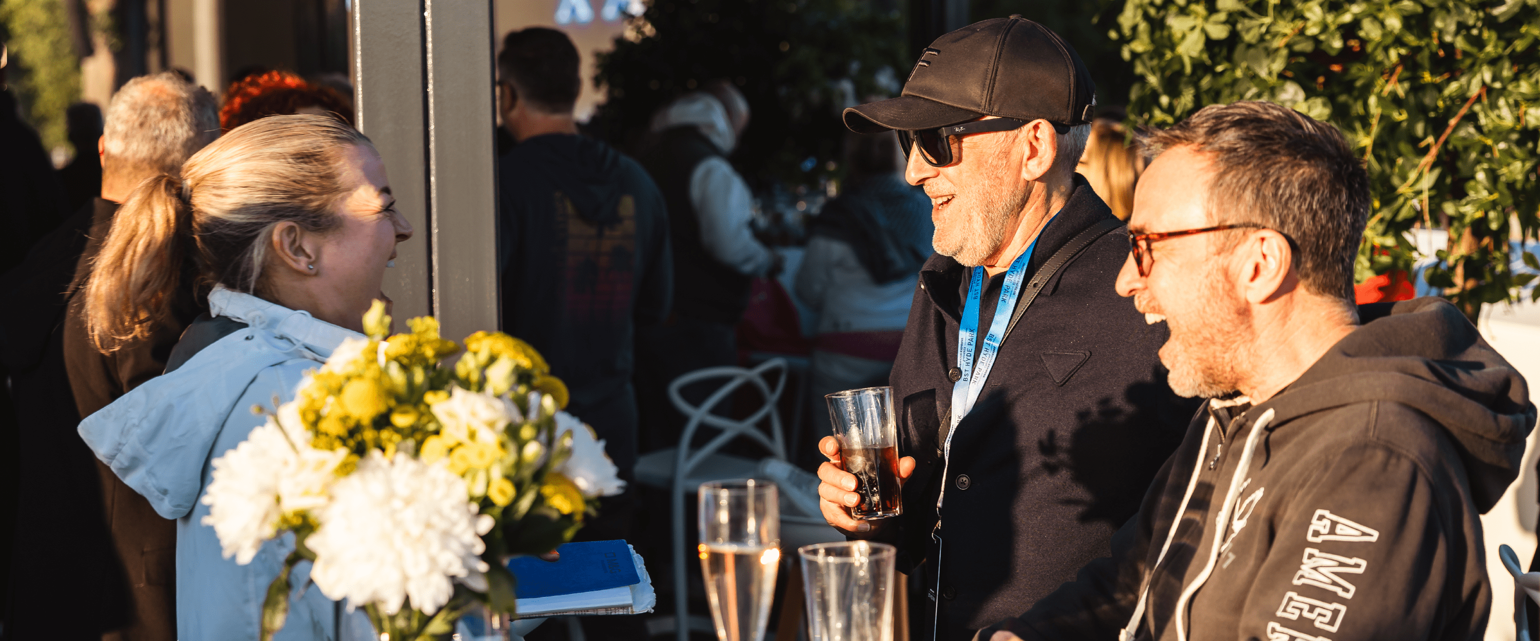 Guests laughing and chatting in the Great Oak Roof Garden hospitality terrace at BST Hyde Park