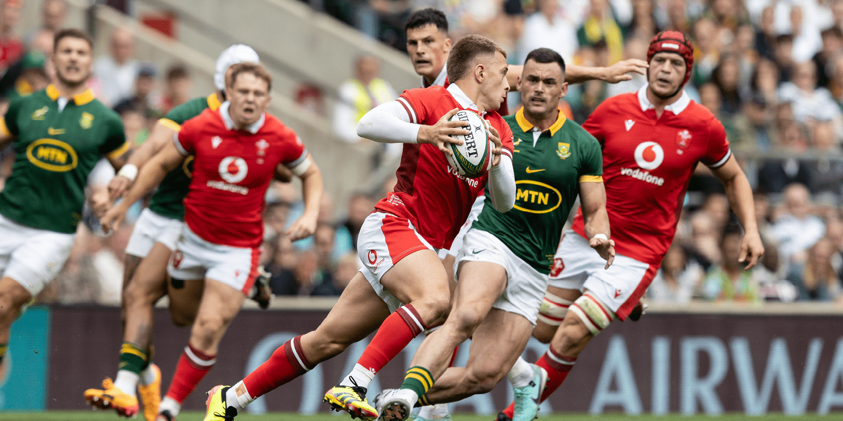 Welsh rugby team running with the ball during a match against South Africa