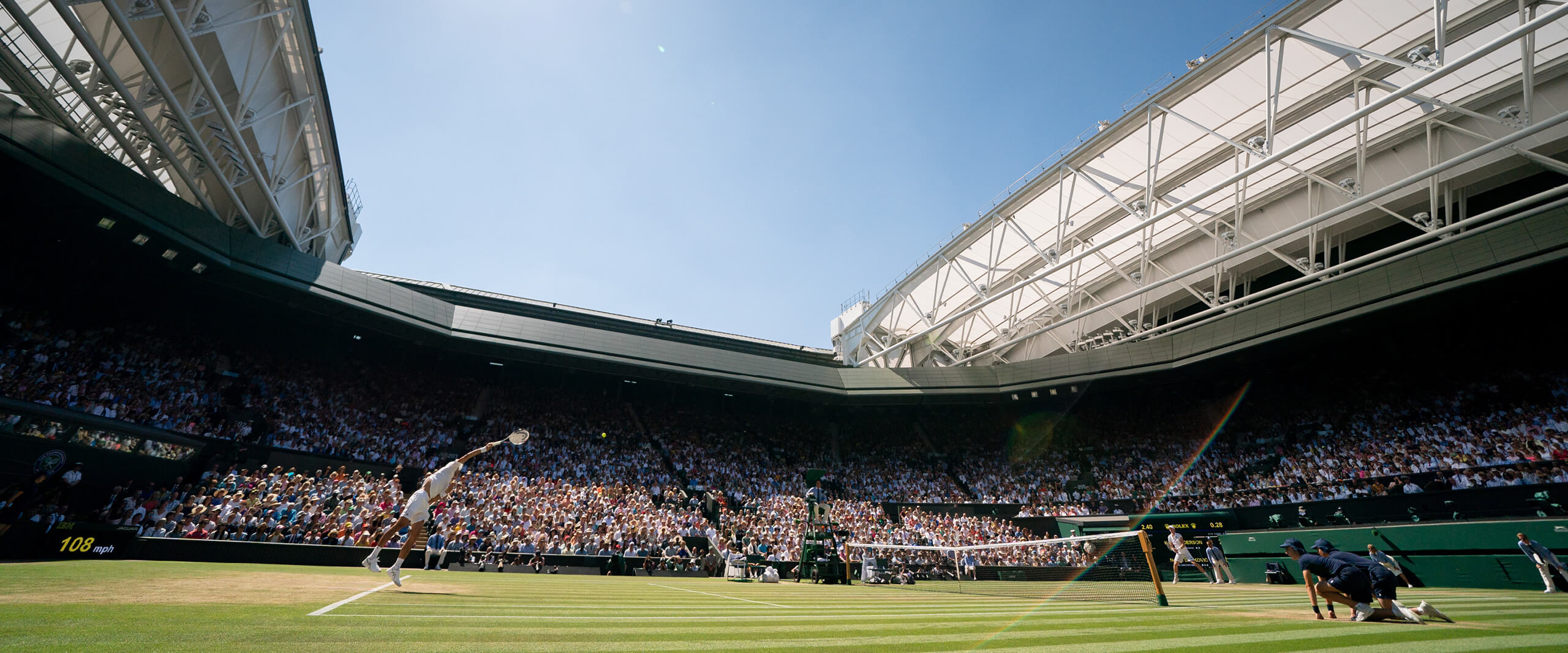 Player hitting a serve on Centre Court at The Championships Wimbledon