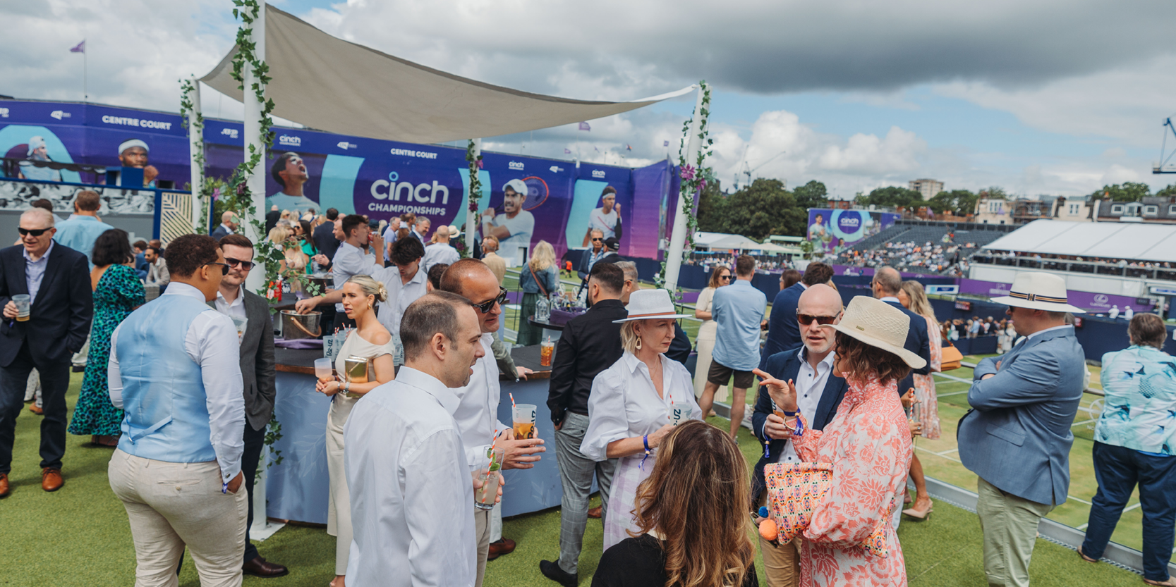 Guests enjoying drinks on the Roof Garden private balcony overlooking the practice courts at The Queen's Club for the championships