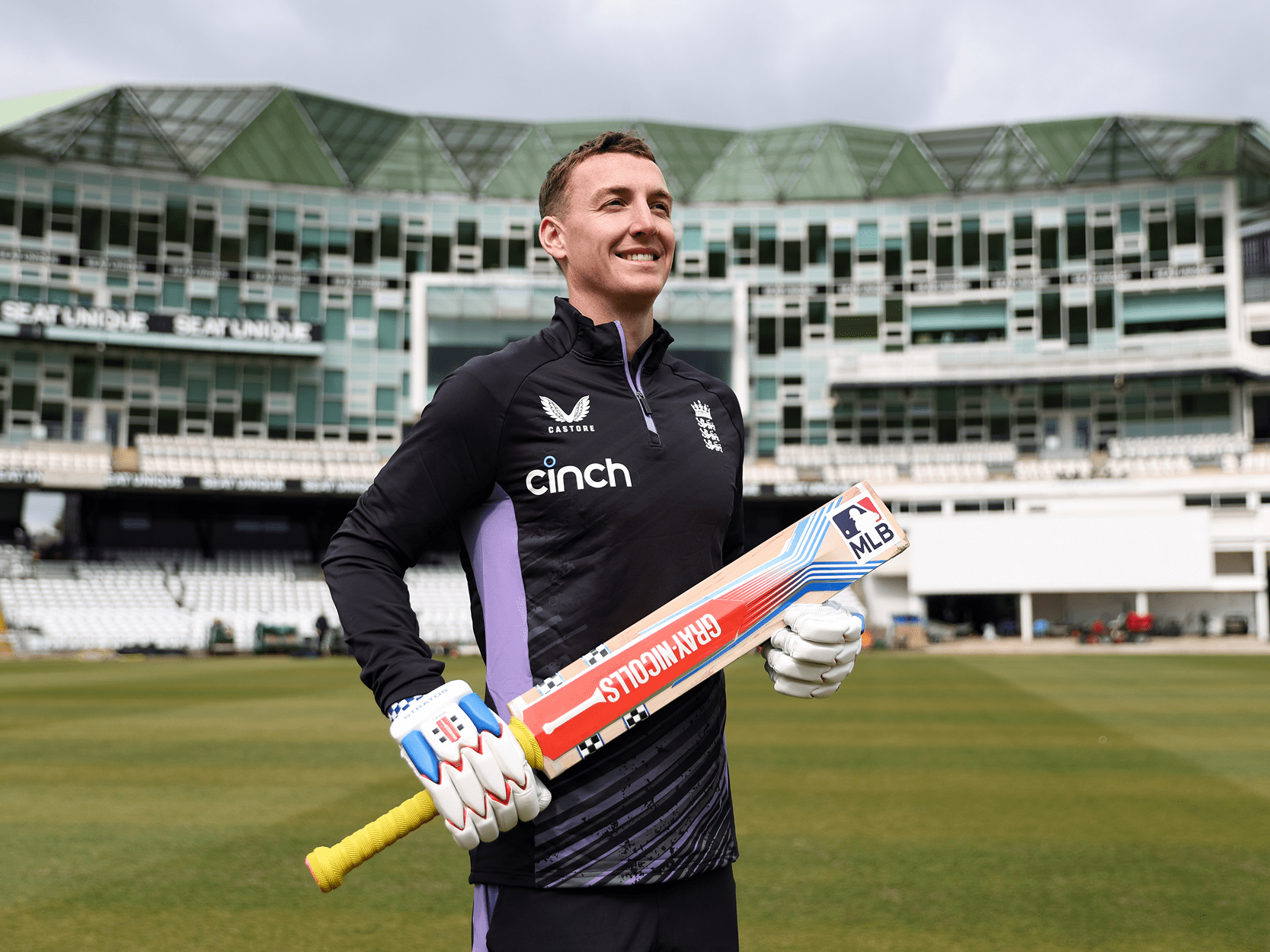 New England white-ball cricket captain for 2025 Harry Brook smiling and holding a cricket bat for the announcement of becoming captain on a cricket pitch