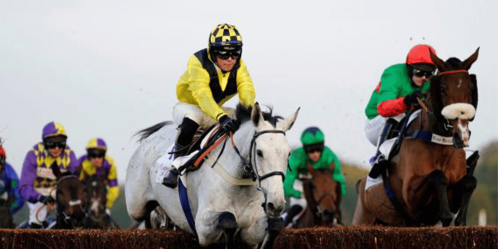 Jockeys racing horses during a jump racing event in England