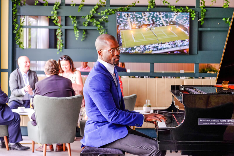 Pianist OKIEM playing in Rosewater Pavilion hospitality space at The Championships Wimbledon 