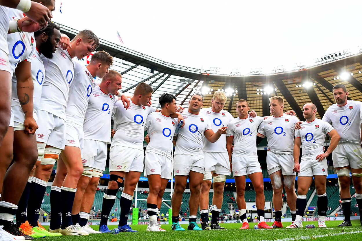 England rugby squad huddled together in team talk on the pitch