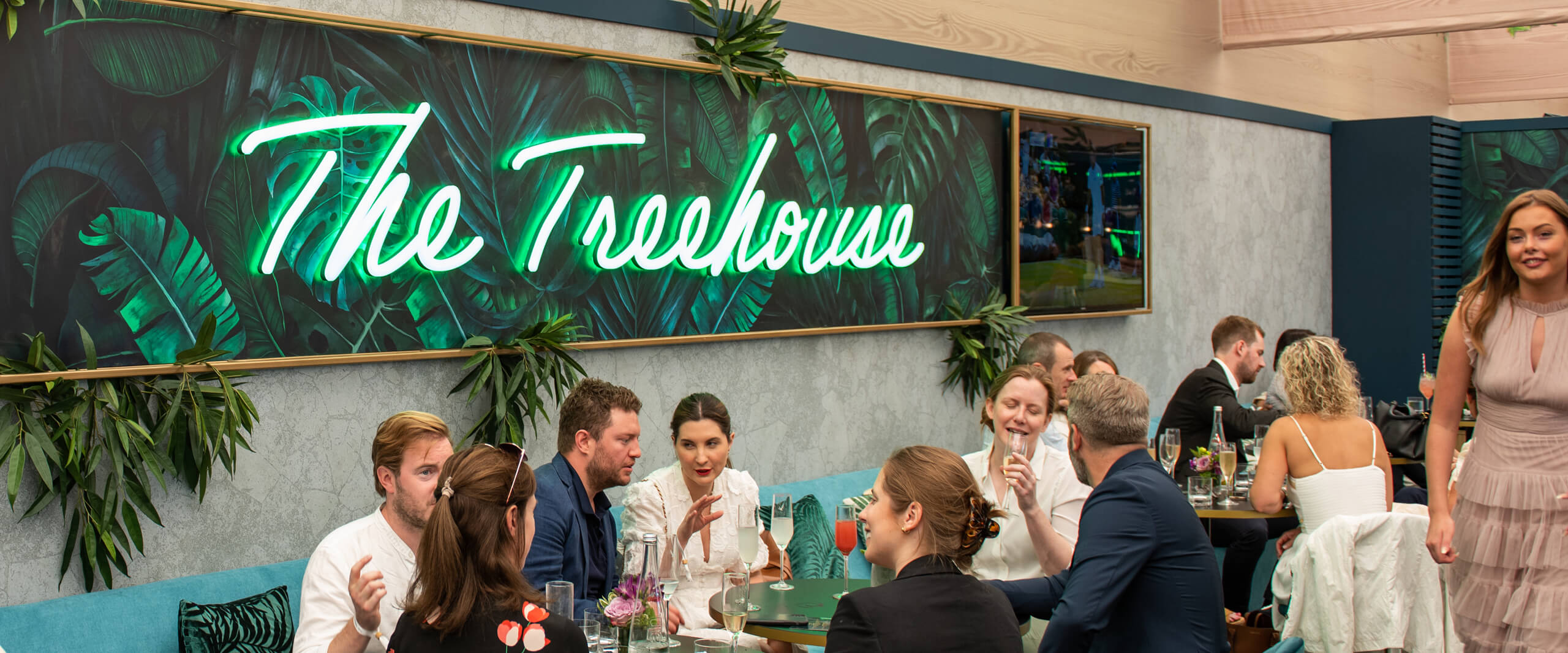 Guests seated enjoying food and drinks inside the Treehouse