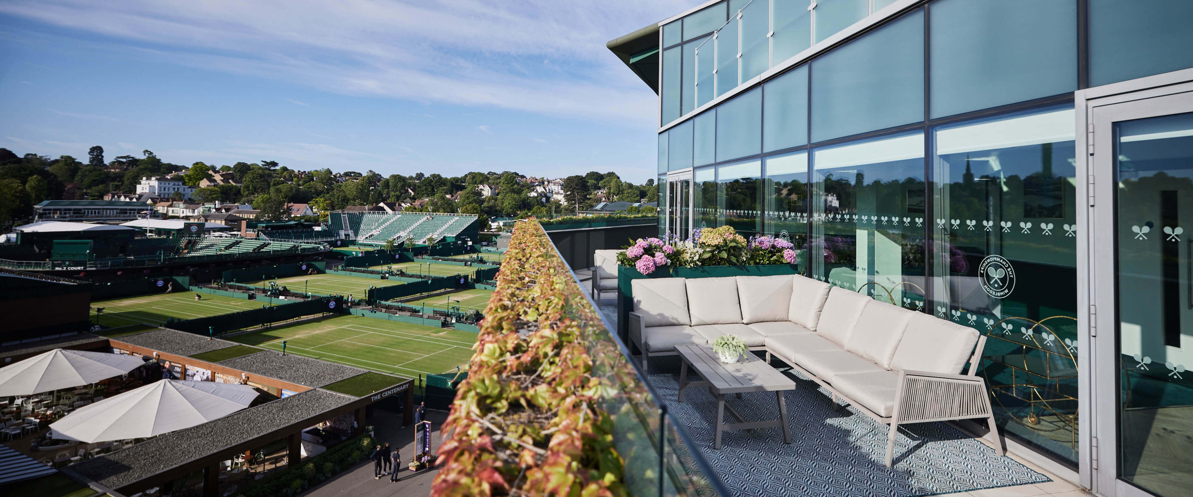 The Skyview Suites hospitality facility terrace with sofa seating overlooking the courts at The Championships Wimbledon