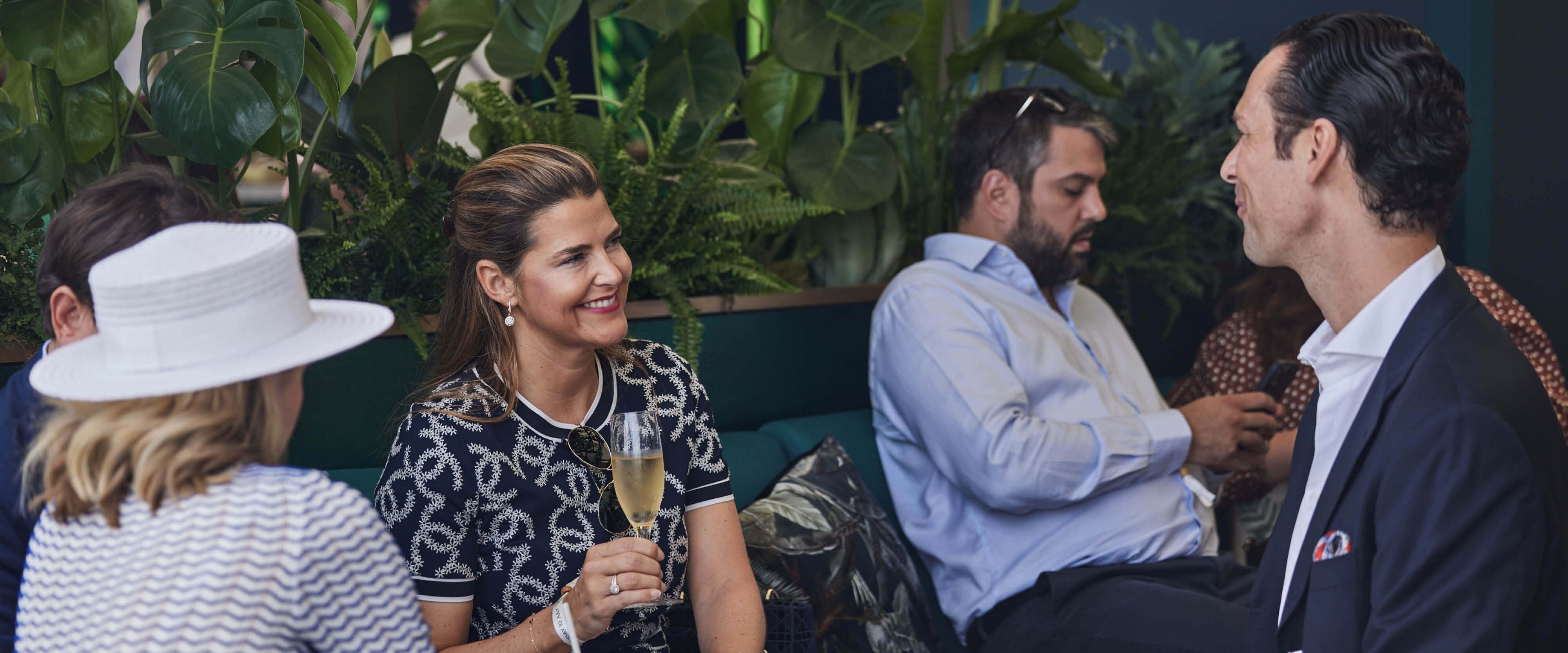 Guests sat down drinking Champagne in the Treehouse hospitality facility at The Championships, Wimbledon